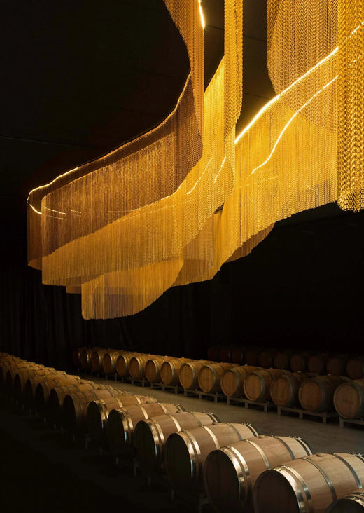 Ottella – Barriquekeller mit goldener Lichtinstallation